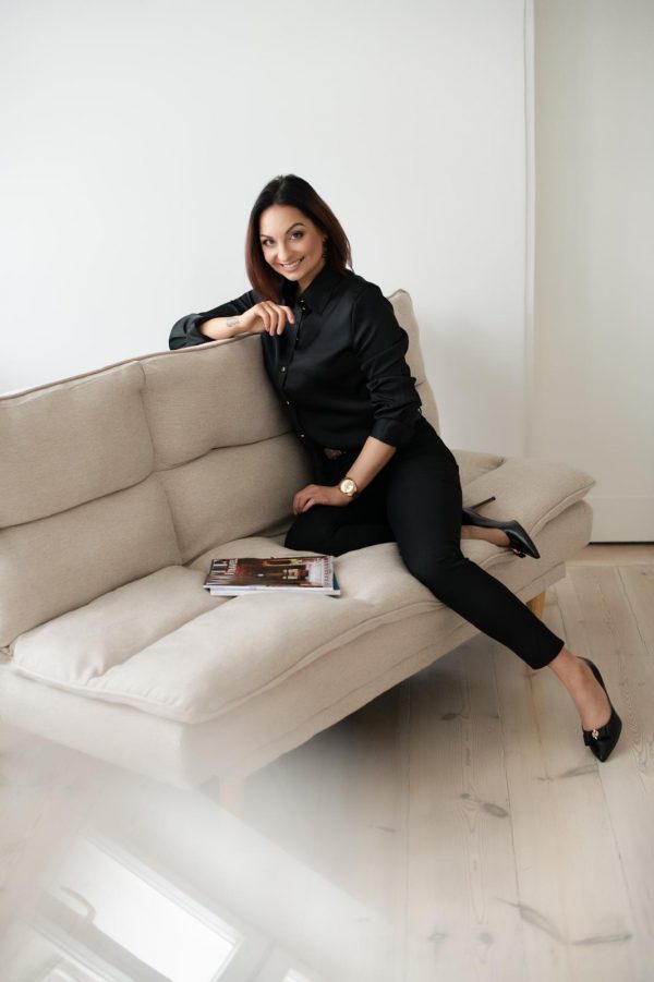 Arleta entspannt auf dem Sofa, ihren eleganten Stil zeigend. Sie sucht einen Partner, der ihre Leidenschaften und Werte teilt. Partnervermittlung für erfüllende Beziehungen.