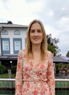 Profilbild von Liubov, 38 Jahre alt, in einem geblümten Kleid vor einem Gewässer und einem stilvollen Gebäude. Ukrainische Single Frauen, die eine ernsthafte Beziehung suchen.